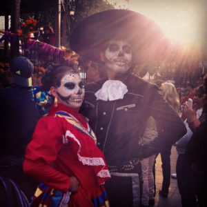 Una pareja de baile vestida con trajes tradicionales y la cara pintada para el Día de los Muertos