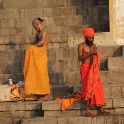 Dos saddhus se vuelven a vestir tras sus rituales mañaneros